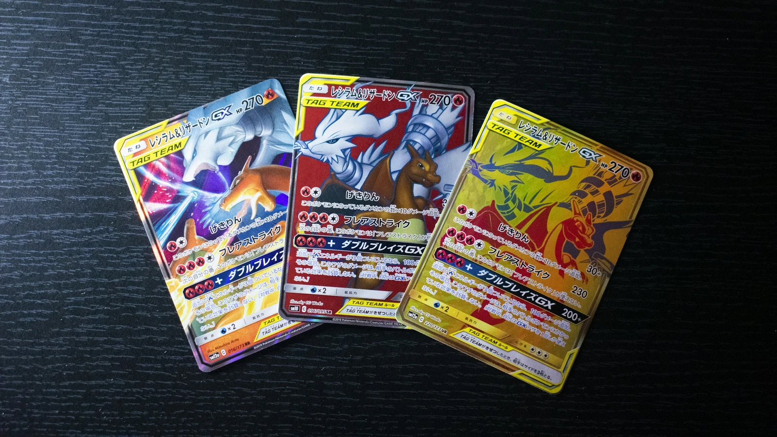 Three Japanese Pokémon cards showing different versions of the same character pairing on a dark tabletop
