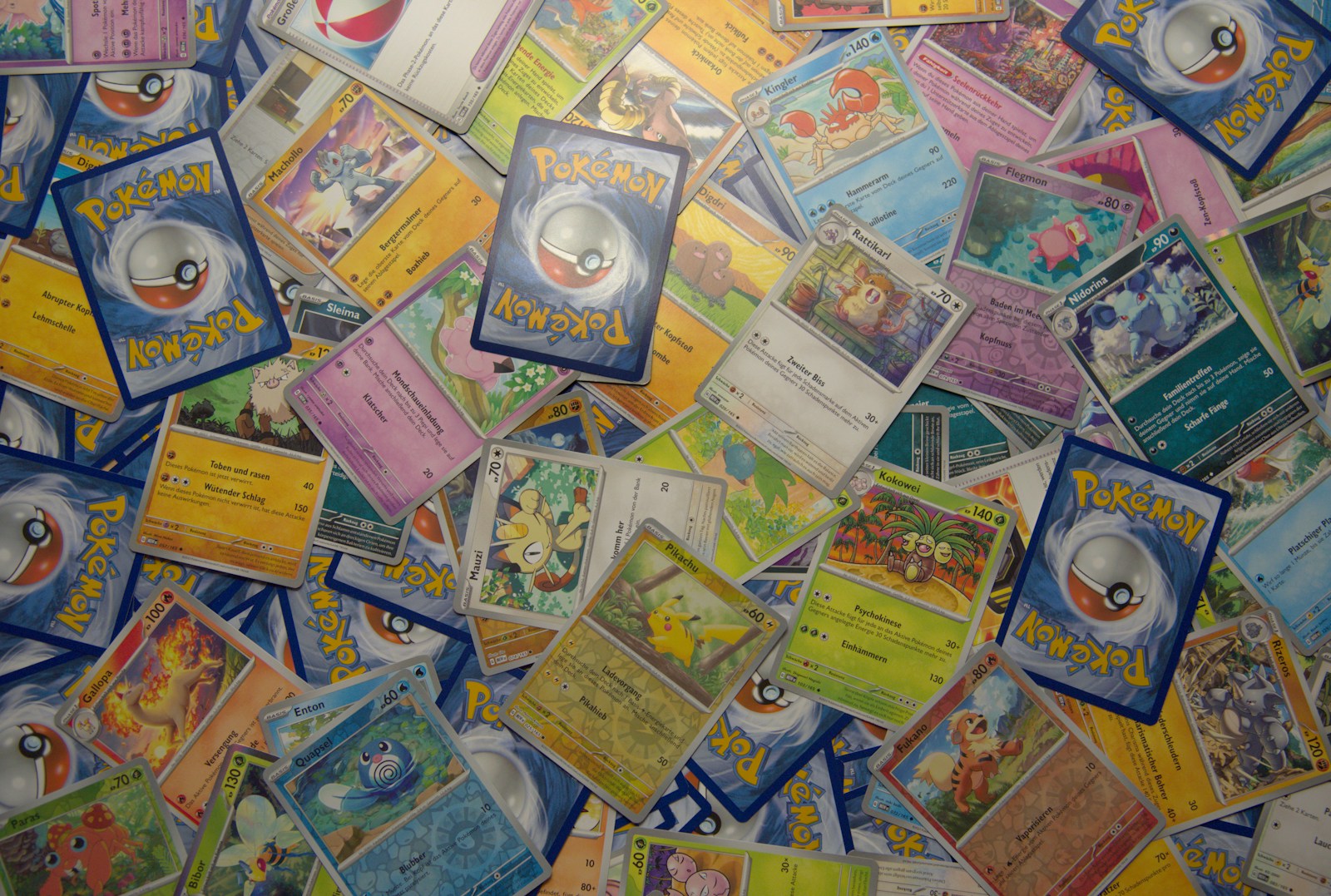 Pokémon single cards spread across a surface, showing card fronts and blue card backs.